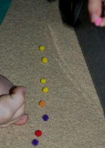 Counting out the pom poms to add as ingredients to the cauldron