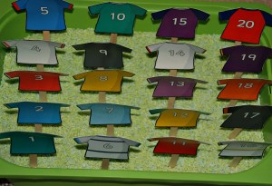 Numbered Rubgy Tops on craft sticks in some green rice on ofamilyblog