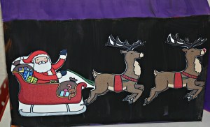 Christmas boxes with Santa on his sleigh using Twinkl stick puppet images