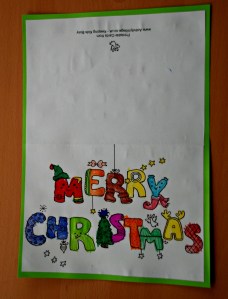 Merry Christmas colouring card stuck onto some coloured paper