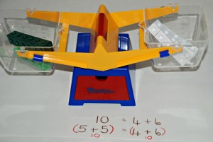 Snap cubes and learning resources scale to introduce the idea that two sums can be equal