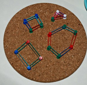 exploring shapes on our cork board with drawing pins and loom bands