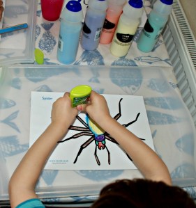 Minibeast sand art - adding his all purpose glue to the colouring page