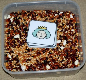 bean sensory tub with words hidden inside and matching pictures left on top