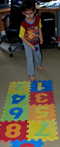 Throwing his dice onto the foam hop scotch mat