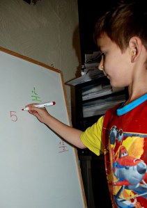 Writing his sums out on the white board