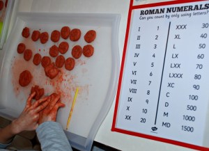 Making clay Roman coins. Using air drying clay and a Roman Numeral poster