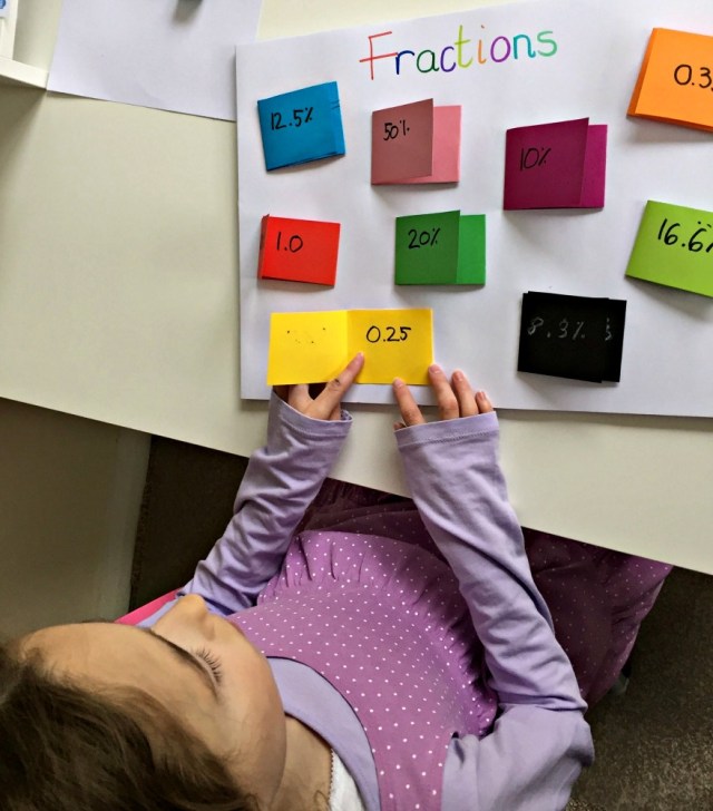 Using our home-made fraction poster to see if she remembers which decimal and which percentage match