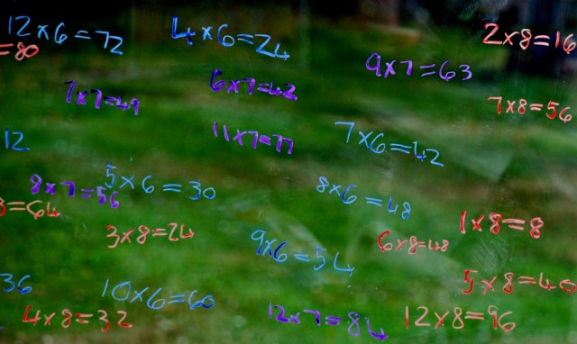 Practicing times tables by writing out the sums on the sliding doors at home