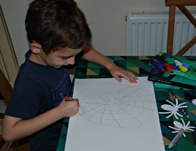 Drawing his spider picture using the spider templates from Activity Village
