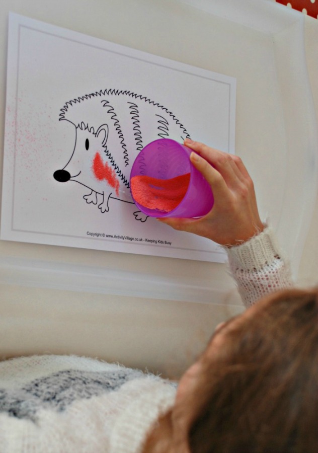 Adding coloured sand to a colouring page from Activity Village to turn it into Sand Art