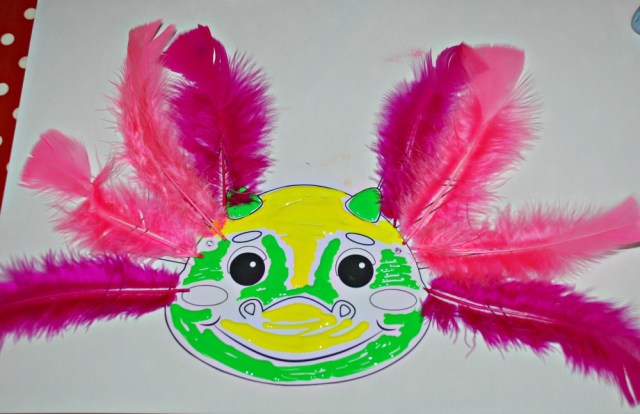 Dragon mask from Activity Village decorated with paints and feathers