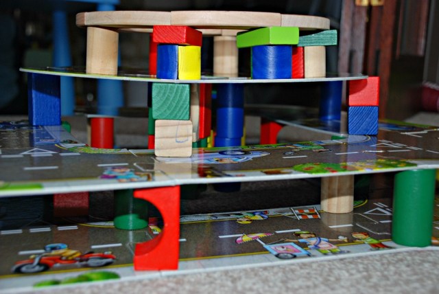 building multi-leveled road structures using his giant road puzzle and some wooden blocks