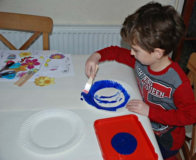 Painting cut out paper plates for the flower wreaths