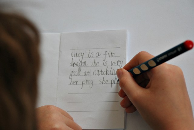 Writing about Lucy the Fire Dragon in a Dragon booklet from Activity Village