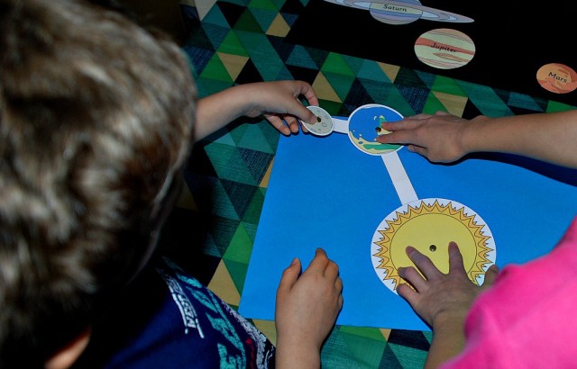 Activity Village orbit model. Shows the moon orbiting the earth while the earth orbits the sun