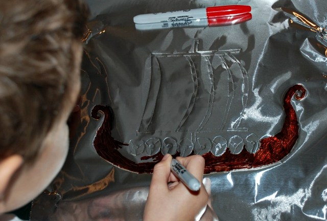 Colouring in our Viking Longship picture that we created on the tin foil
