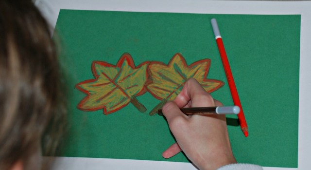 Using her chalk pastels to create some Autumn leaves