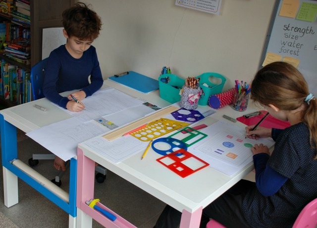 creating maps at their desk using grid paper and some stencils