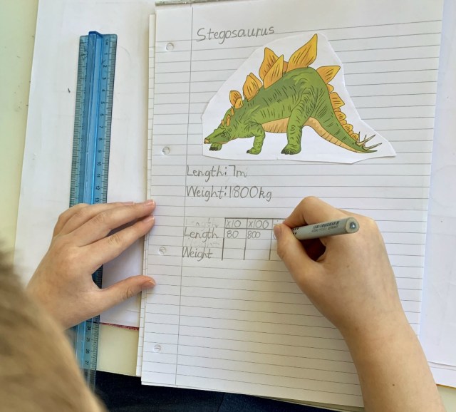 creating dinosaur fact pages to use for his dinosaur maths activity